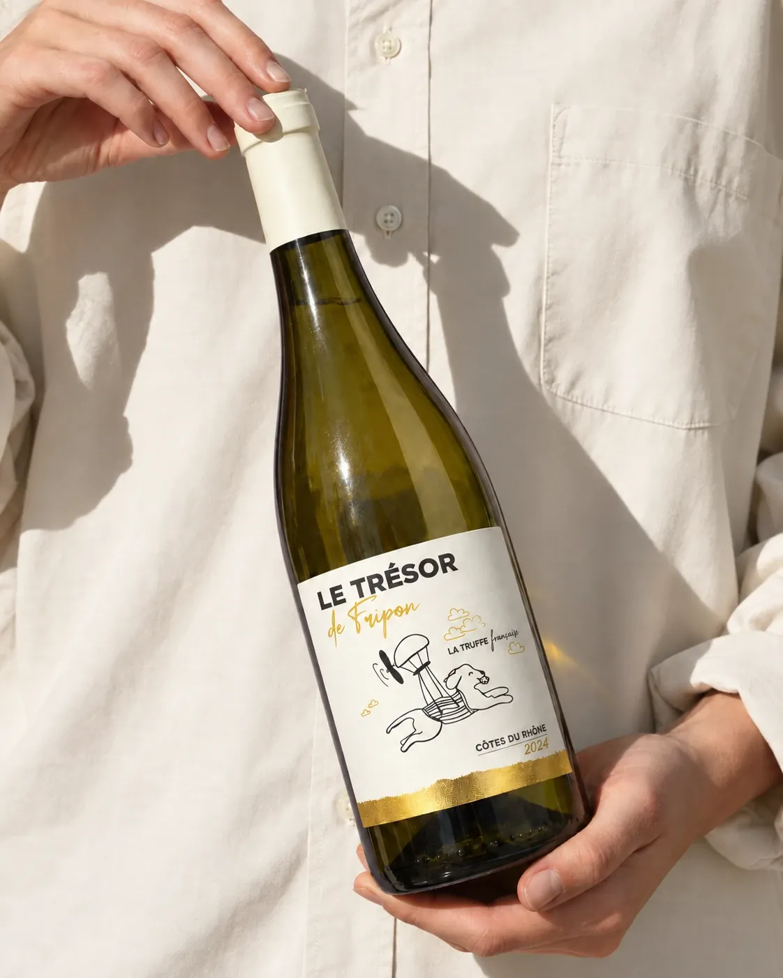 一人展示一瓶 Le Trésor de Fripon 白葡萄酒