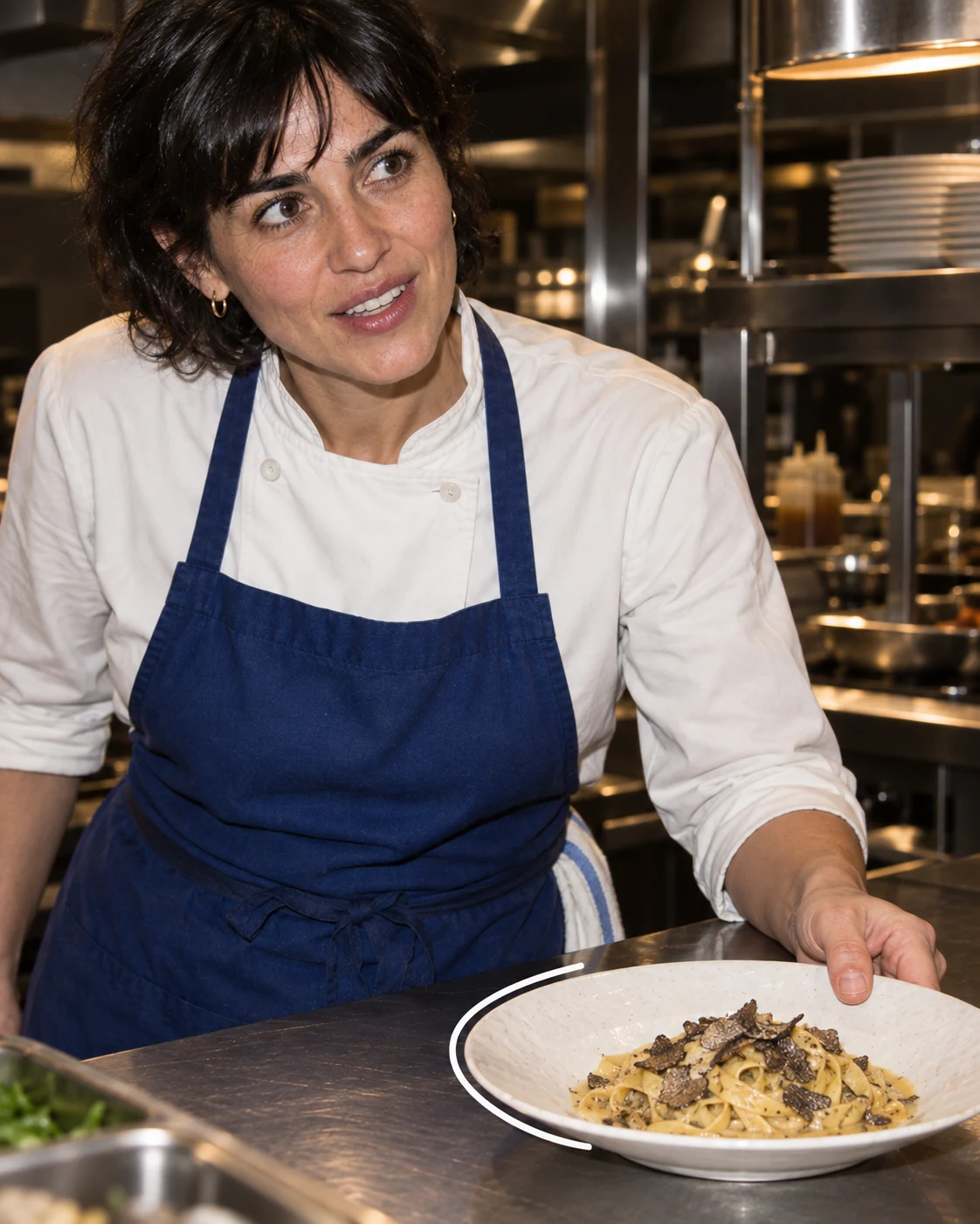 Cuisinière présentant une assiette de pâtes à la truffe